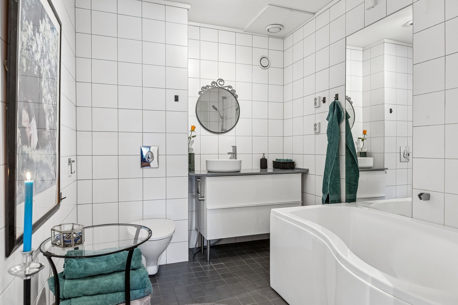 Her er vi inne på det romslige badet med badekaret, det store spieilet og god plass til saker og ting ved vaskeservanten. Galleribilde