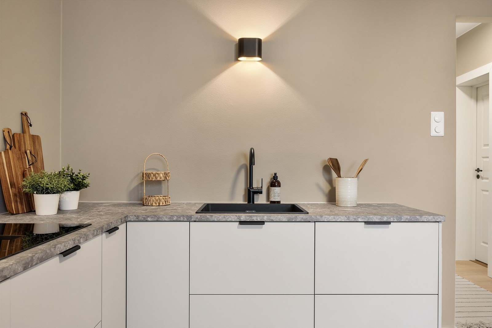 Detaljer som sort, ett-greps kran og nedfelt kum understreker den gjennomførte stilen. Galleribilde