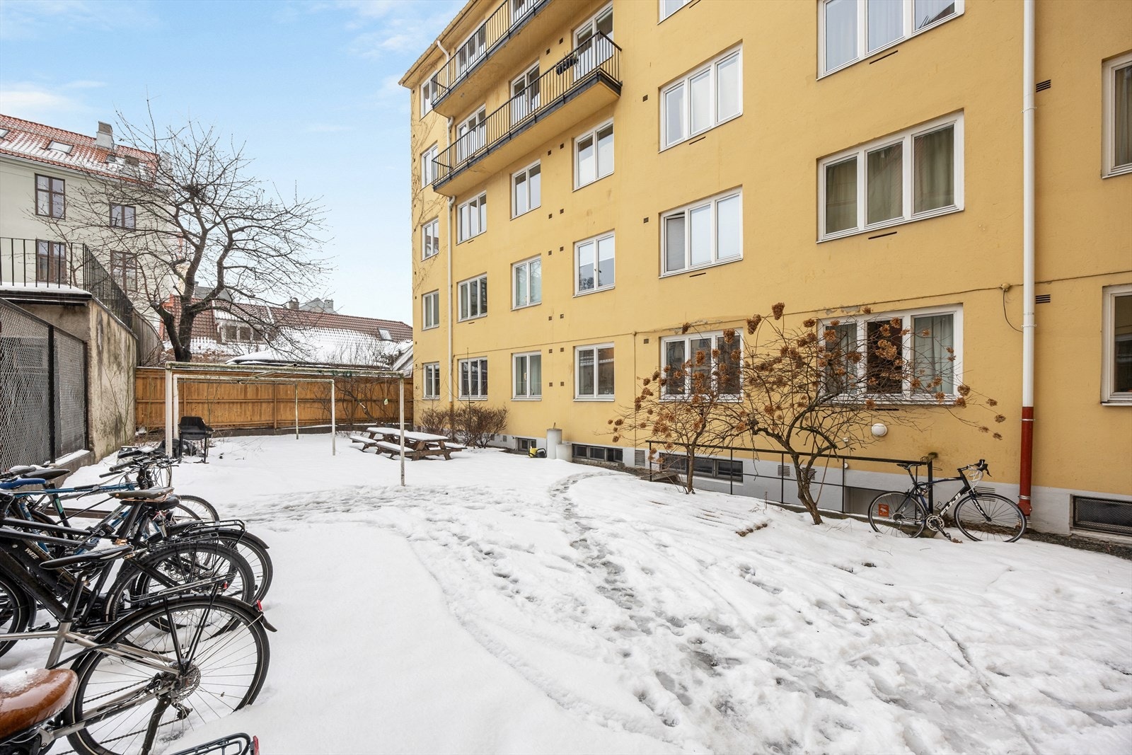 Bakgården er et hyggelig fellesområde med plass for sykkelparkering og utemøbler. Galleribilde