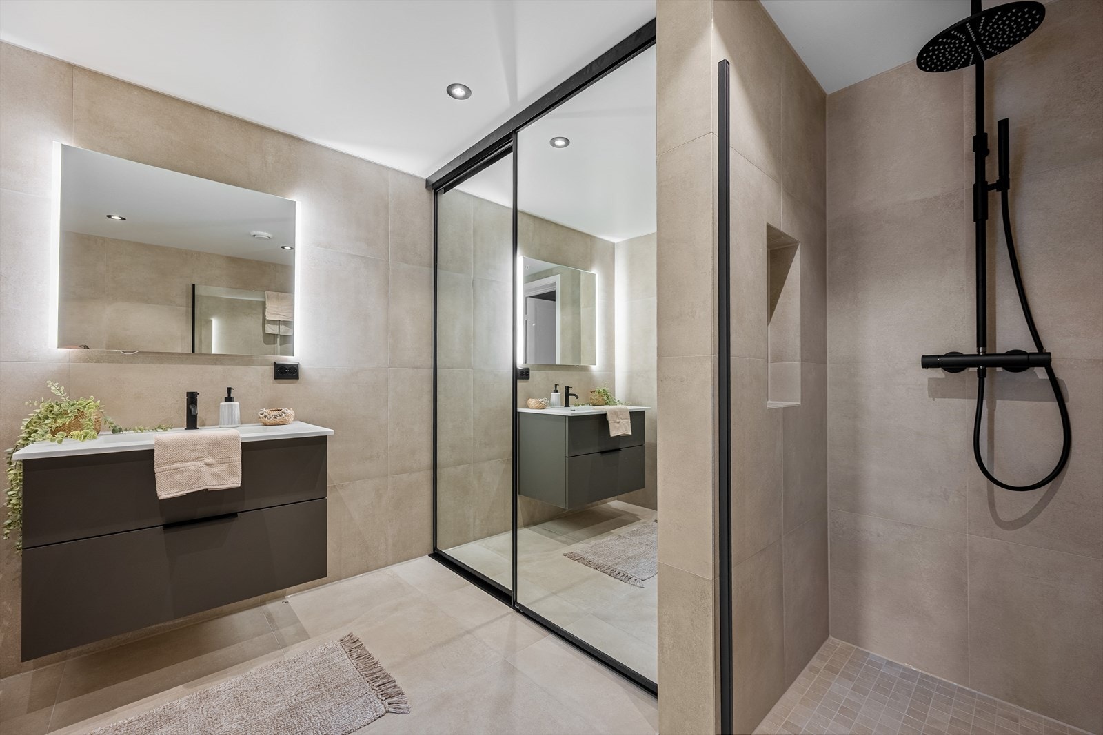 Badet er ellers utstyrt med dusjhjørne, veggehengt toalett og baderomsinnredning med nedfelt servant. Bak speildører har man opplegg for vaskemaskin - Praktisk løsning som gir et renere uttrykk. Galleribilde