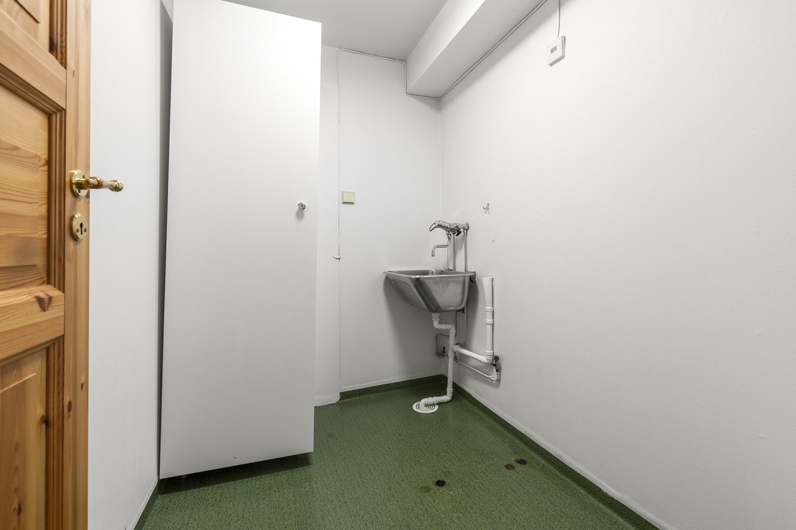 Praktisk vaskerom med utslagsvask og opplegg for vaskemaskin. Galleribilde