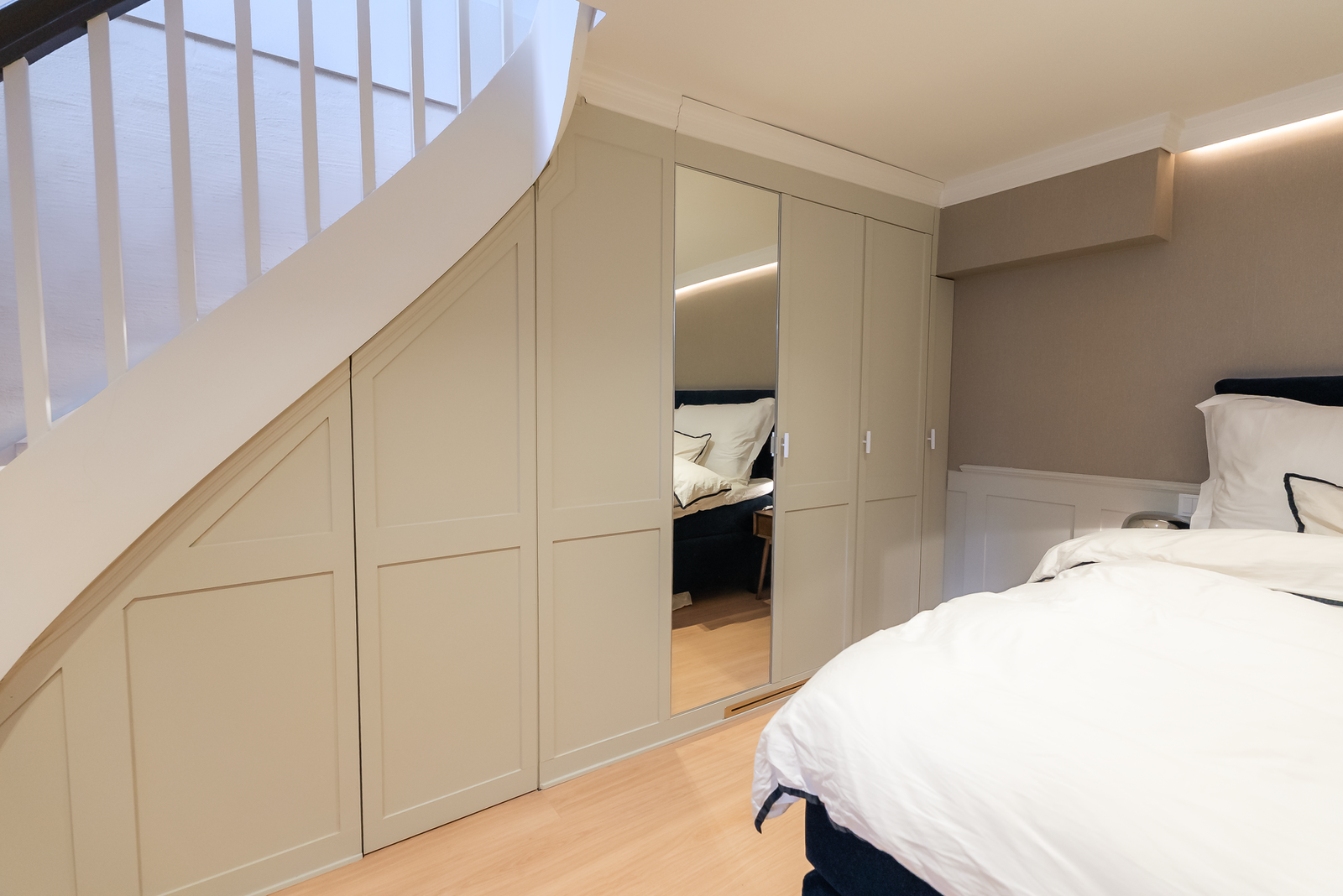 Plassbygd garderobeløsning gir rikelig med lagringsplass, samt skreddersydde skap og oppbevaringsløsninger under trappen for maksimal lagringskapasitet. Galleribilde