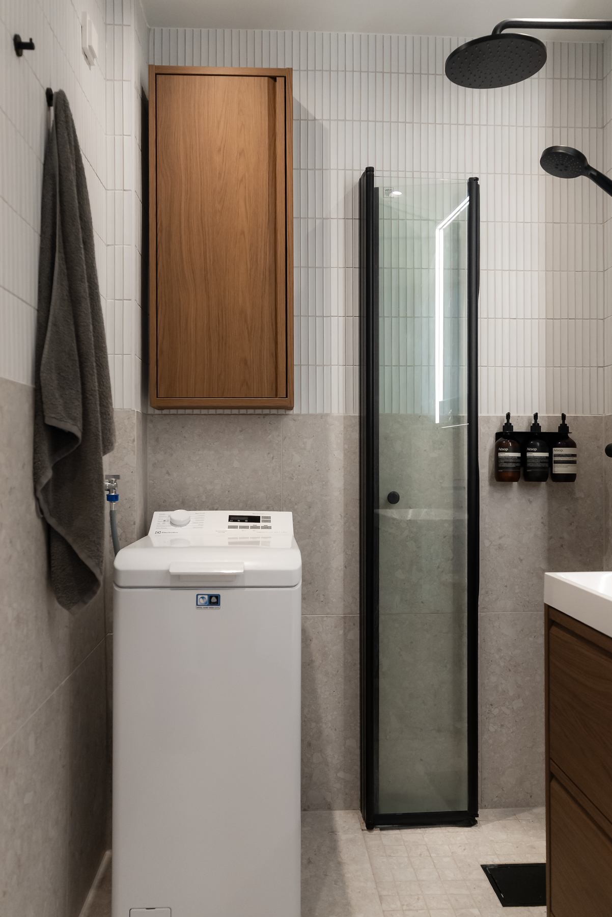 Badet er delikat flislagt med en kombinasjon av hvit fingermosaikk og italienske fliser i greige terrazzo stil. Det er selvfølgelig gulvvarme, samt opplegg for vaskemaskin. Galleribilde