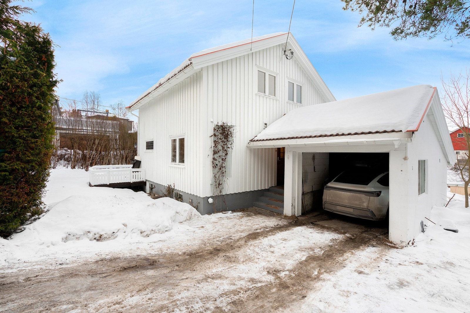 Bilen står trygt parkert i garasje ved inngangsparti. Det er ellers god biloppstillingsplass på gårdsplass Galleribilde