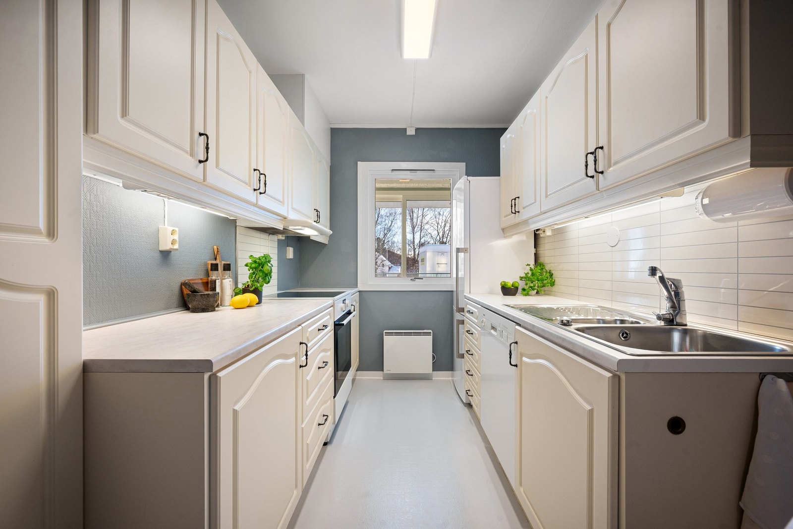 Oppgradert kjøkken med lyse, profilerte fronter og innredning på begge vegger Galleribilde