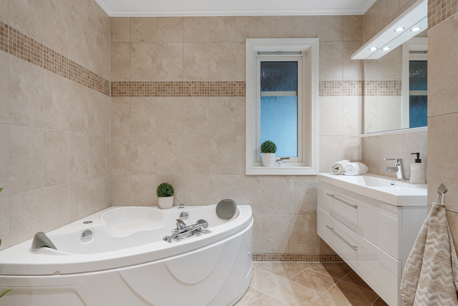 Badet har fliser på gulv og vegger, samt malte himlingsplater som gir et lyst og pent uttrykk. Galleribilde