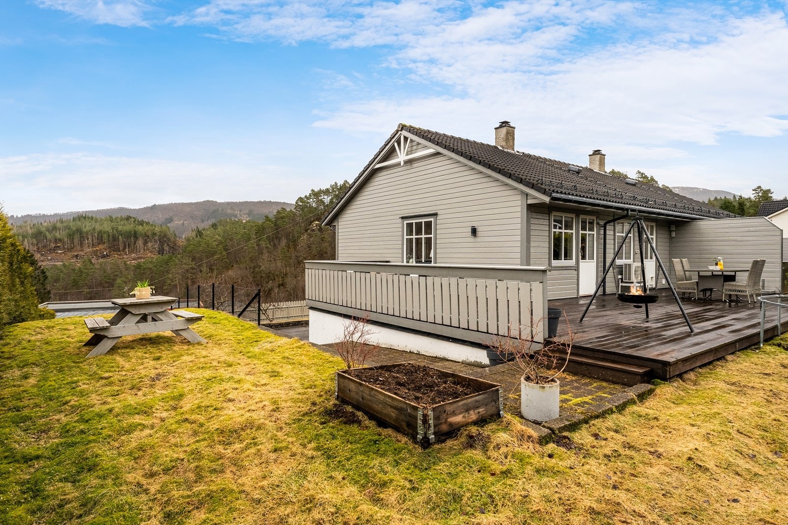 Terrassen strekker seg rundt store deler av huset og gir gode soner for utemøbler og lek. Galleribilde