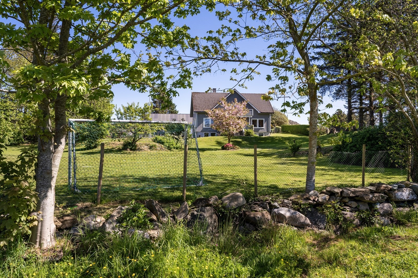 Til boligen er det en stor og idyllisk hage med masse boltreplass for hele familien Galleribilde