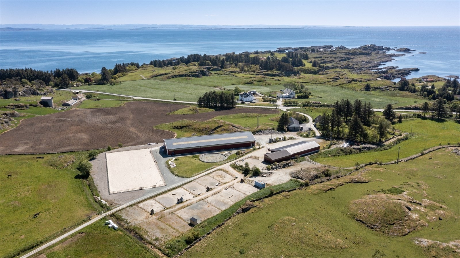 Eiendommen er på hele 208 mål og har godt med plass til hestene - de små luftegårdene nederst i bildet er i dag fjernet grunnet dårlig forfatning, og området er planert på nytt og klargjort for oppføring av nye gjerder Galleribilde