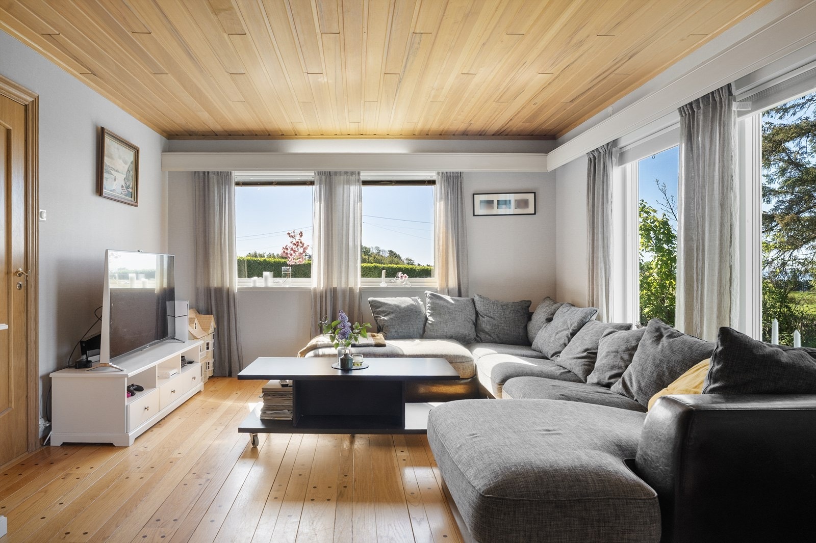 Stor og pen vinkelstue med store vinduer som sørger for masse naturlig lysinnslipp Galleribilde