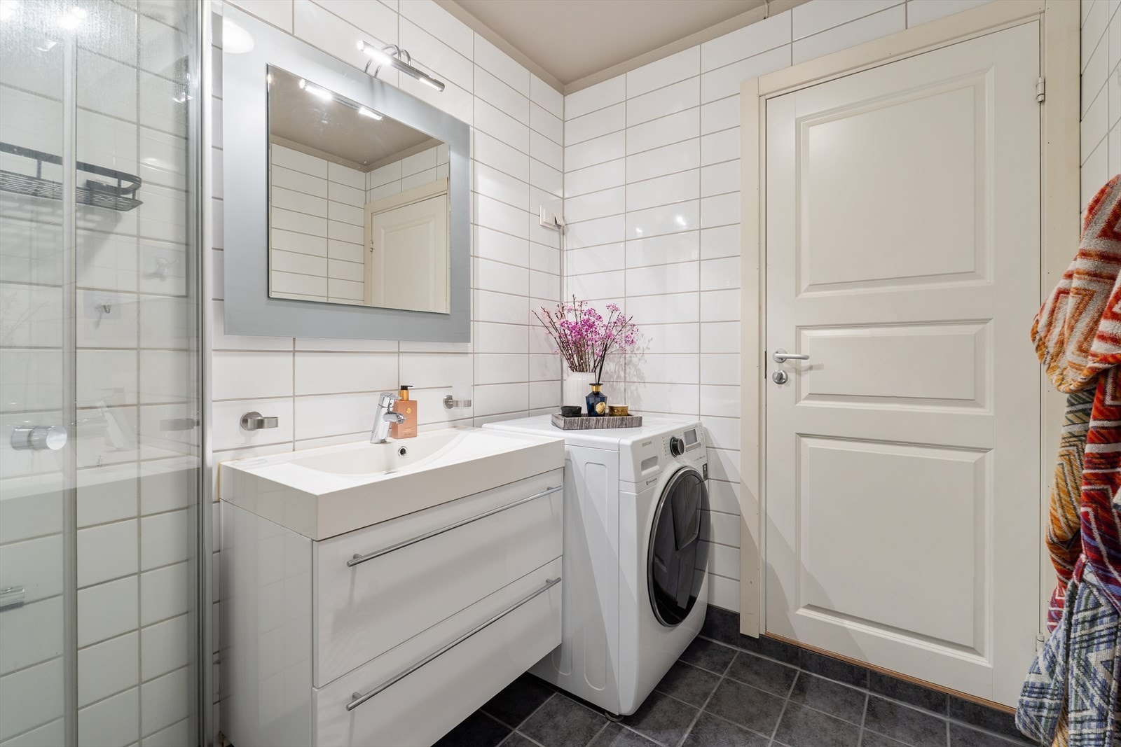 Badet er utstyrt med dusjhjørne med innfellbare dører og har opplegg for vaskemaskin. Galleribilde