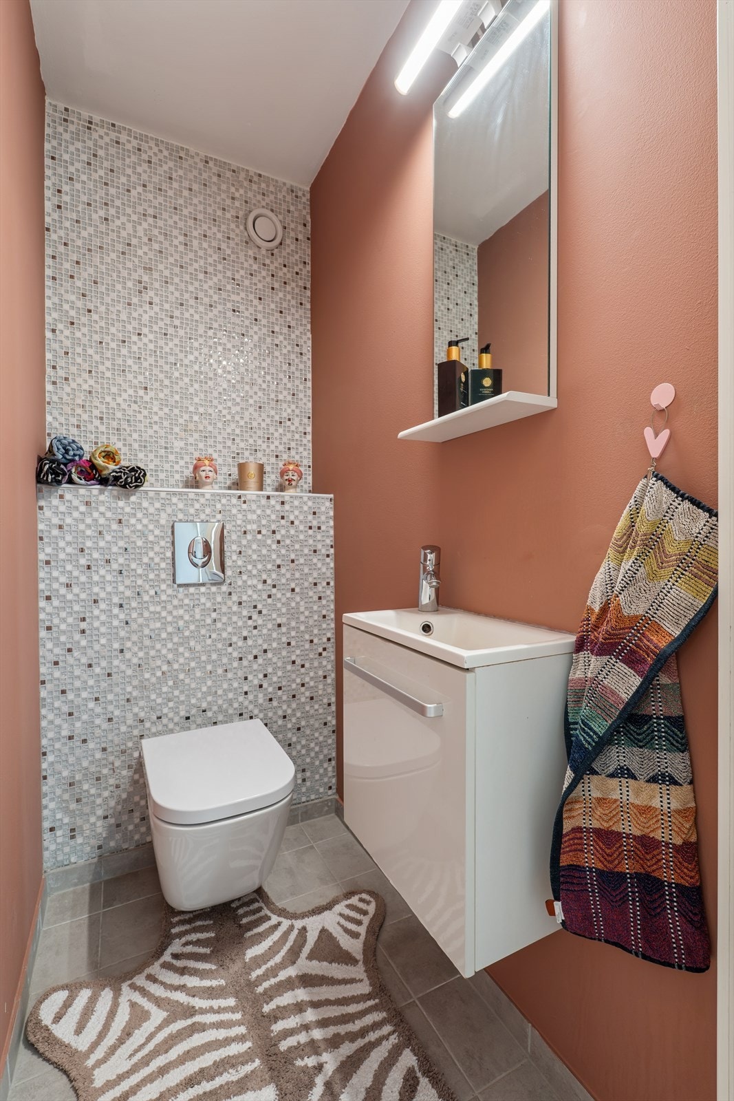 Praktisk, separat toalettrom med vegghengt klosett og servant med underskap. Galleribilde