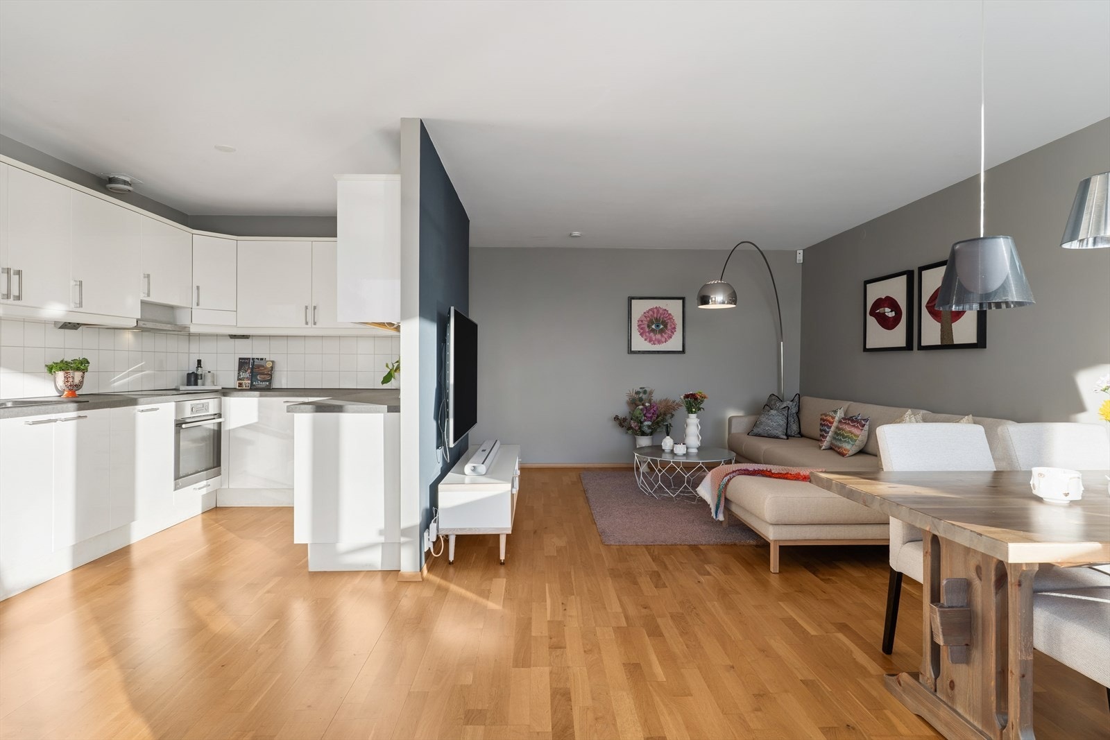 Den delvis åpne løsningen mellom stue og kjøkken skaper en sosial og luftig atmosfære. Galleribilde