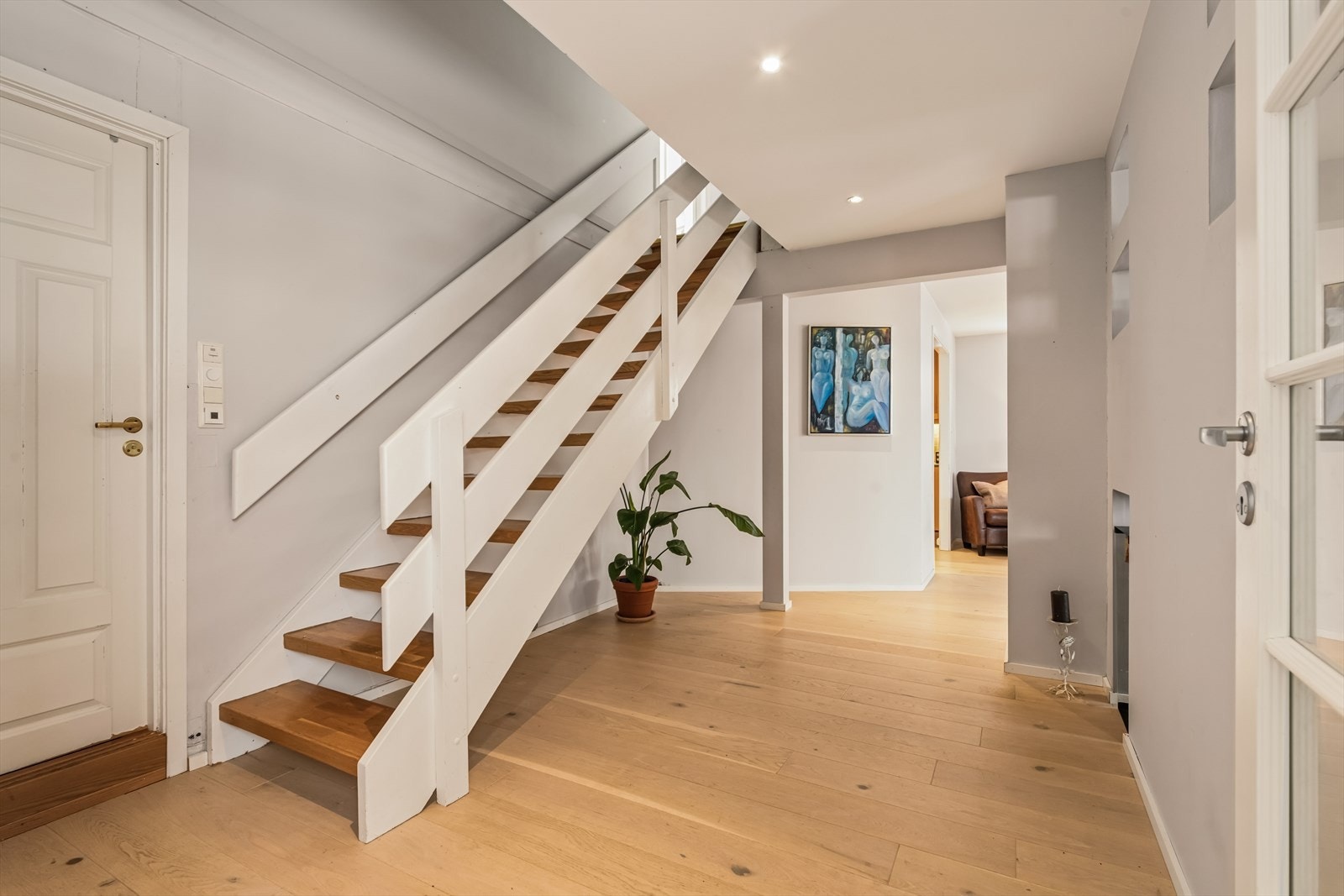 Velkommen inn. Trappen i malt tre med lakkerte trinn forbinder etasjene. Galleribilde