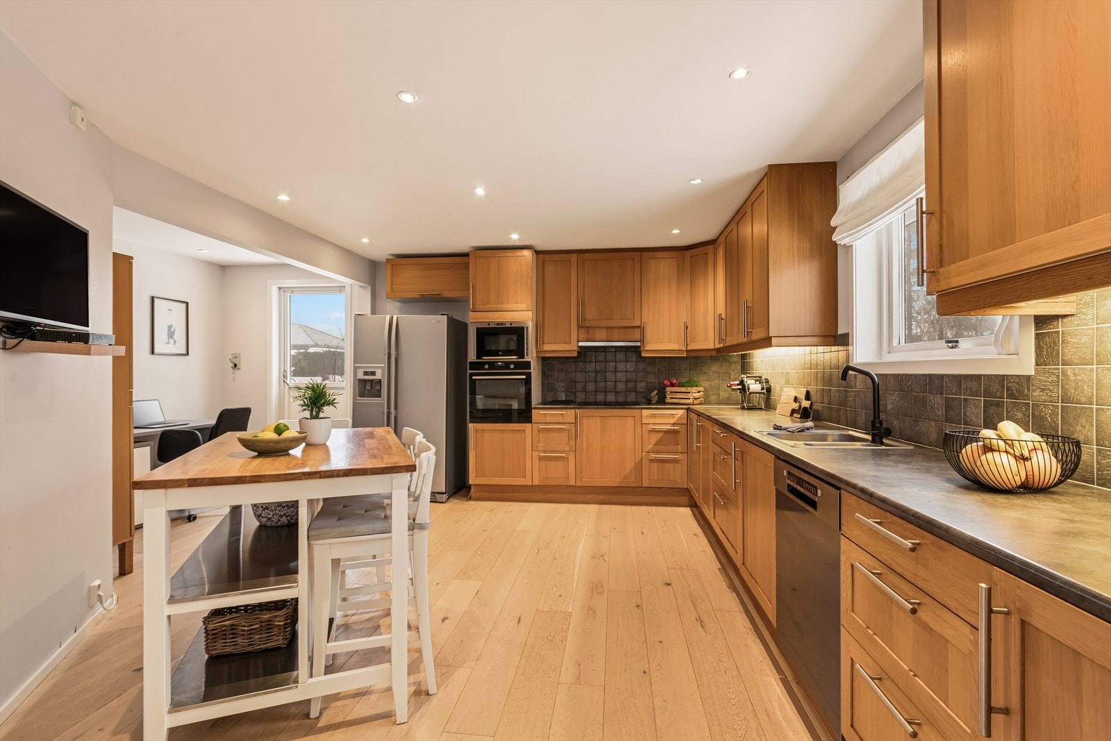 Innredningen har profilerte fronter og laminat benkeplate med nedfelt kum i rustfritt stål. Galleribilde