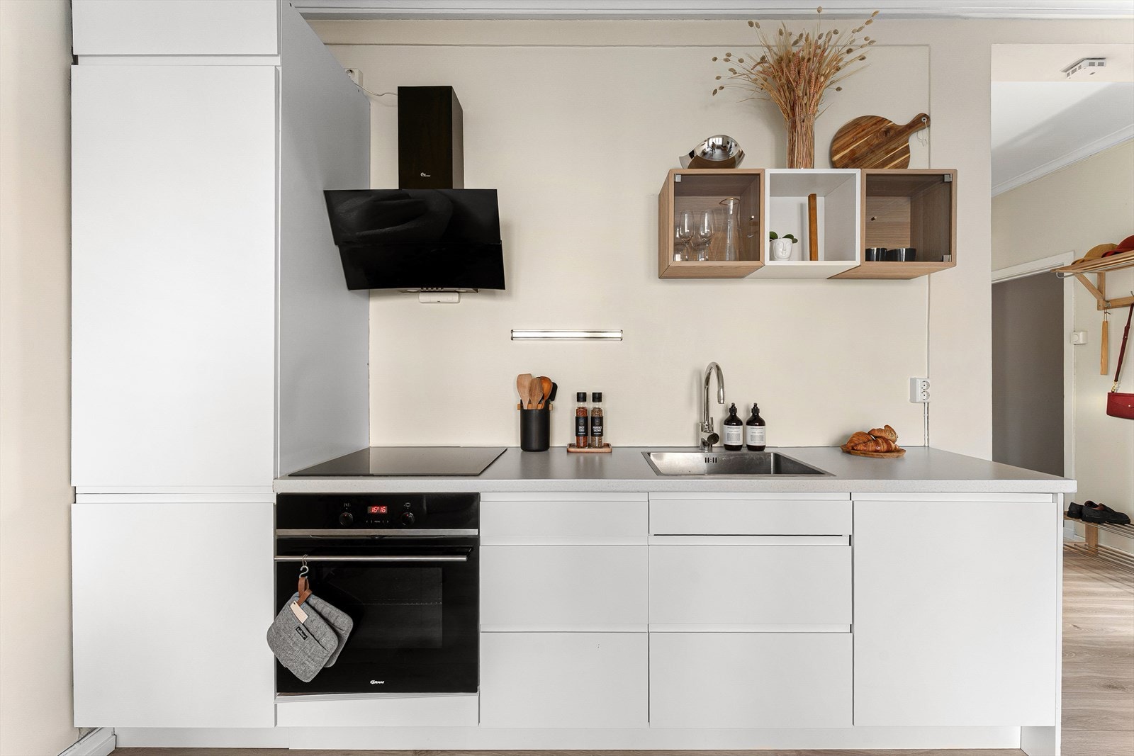 Her får du en funksjonell arbeidsplass med veggmontert kullfilterventilator i stål, samt integrerte hvitevarer bestående av induksjonstopp, stekeovn, oppvaskmaskin og kombinert kjøl/frys. Galleribilde