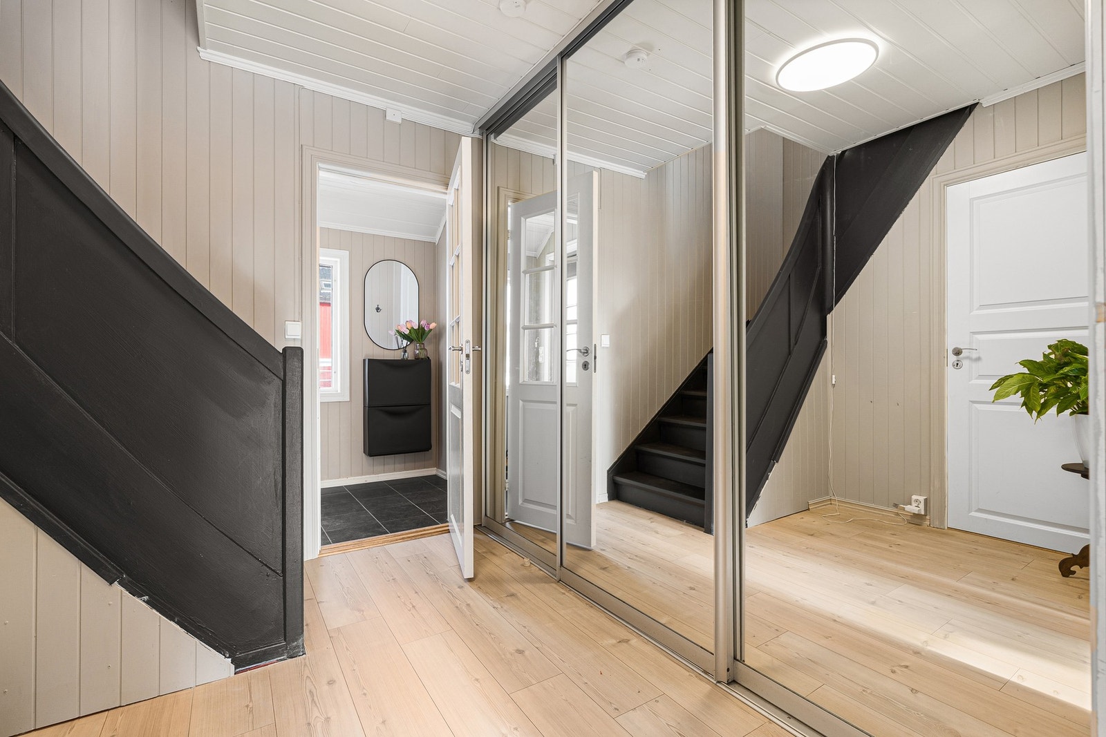 Innbydende gang og inngangsparti med gode oppbevaringsmuligheter i skyvedørsgarderobe. Galleribilde