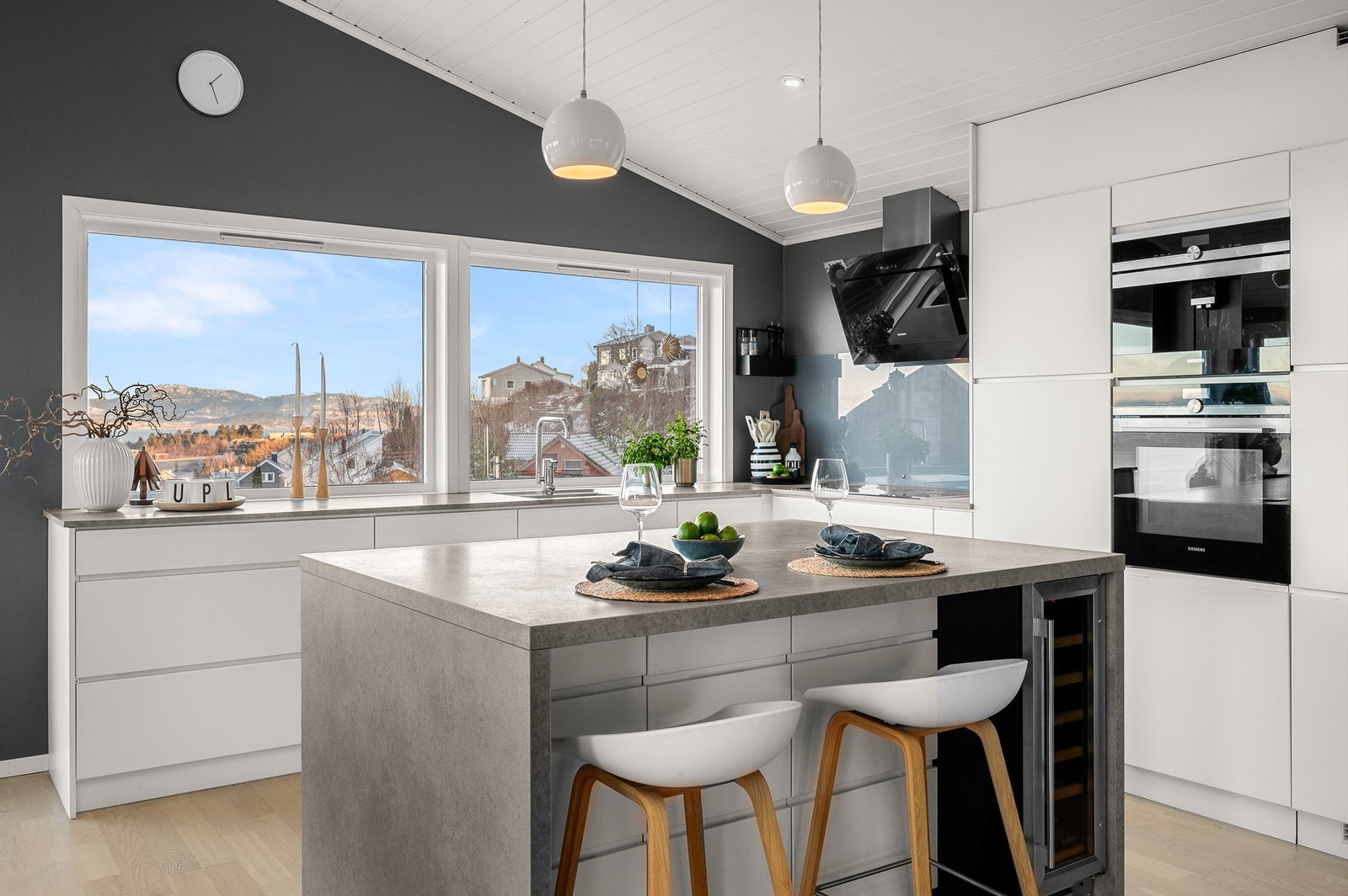 Integrerte hvitevarer og vinskap i kjøkkenøyen gir et helhetlig og gjennomført uttrykk. Galleribilde