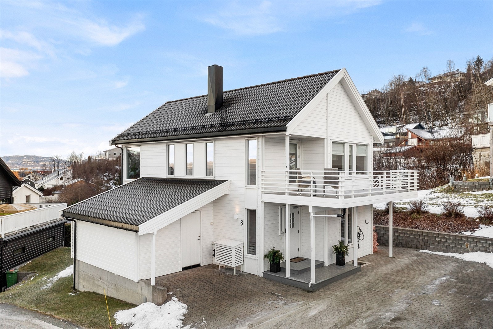 Boligen har flere biloppstillingsplasser i gårdsplassen. Elbil-lader ble installert i 2020 - godt tilpasset en moderne hverdag. Galleribilde