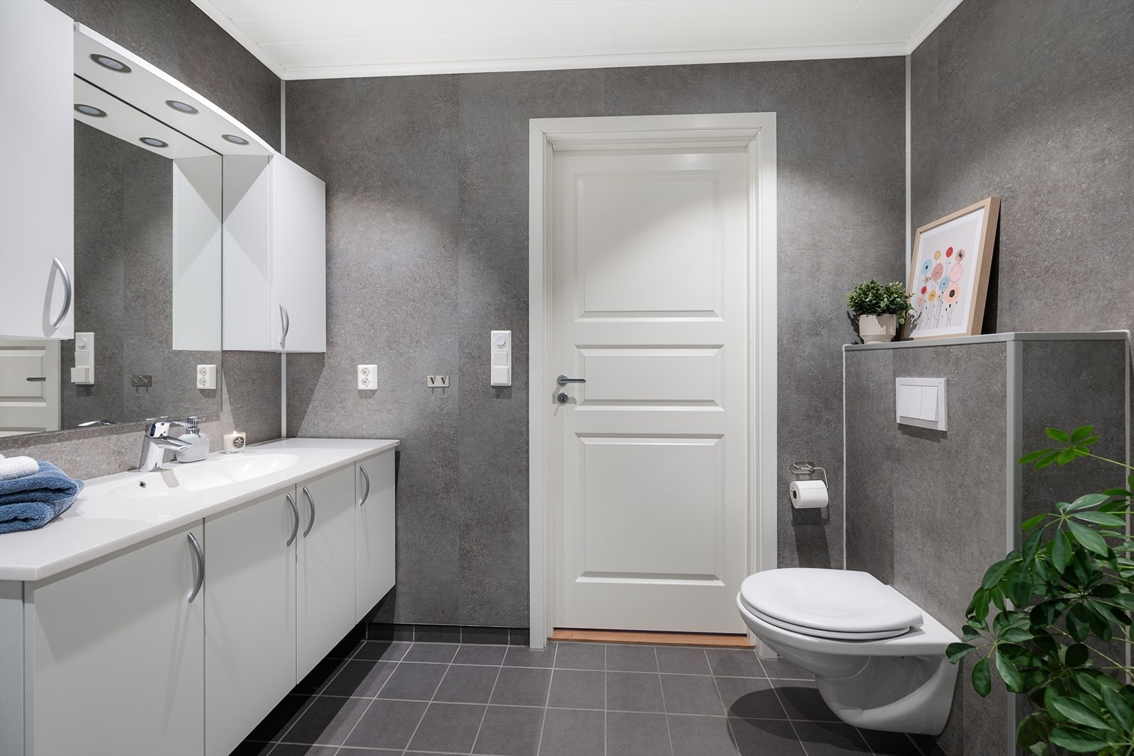 Delikat bad med mørke våtromsplater som gir en fin kontrast til den hvite innredningen. Galleribilde