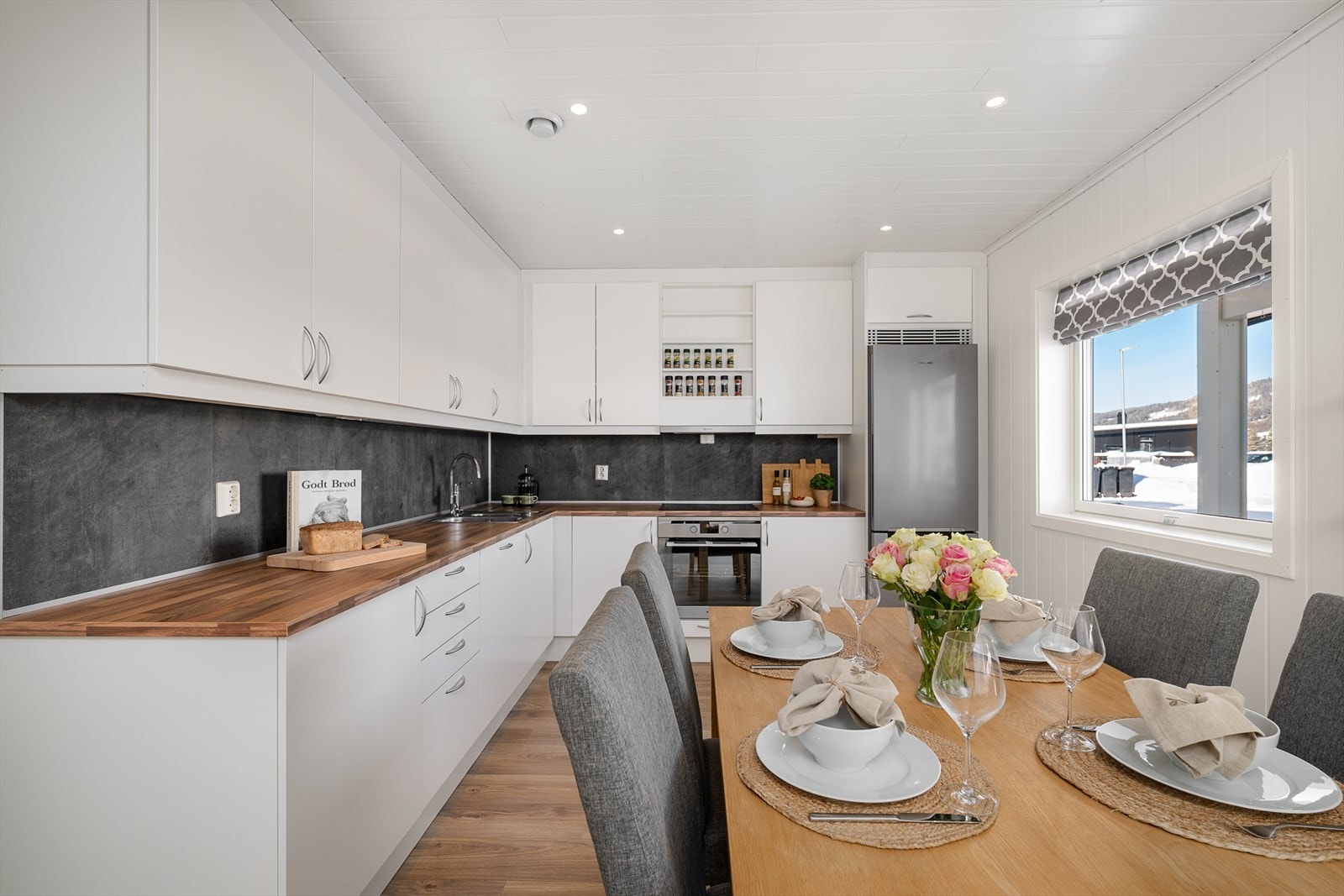 Moderne kjøkkeninnredning med glatte fronter, laminat benkeplate og integrerte hvitevarer. Galleribilde