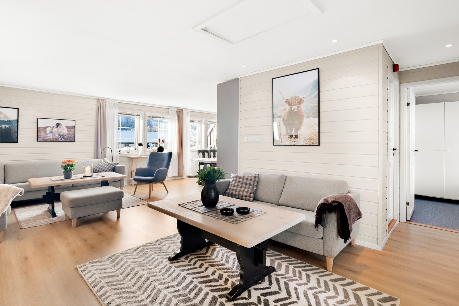 Stua har et praktisk gulv av laminat som er enkelt å holde rent, og vegger med en kombinasjon av tapet og trepanel. Galleribilde