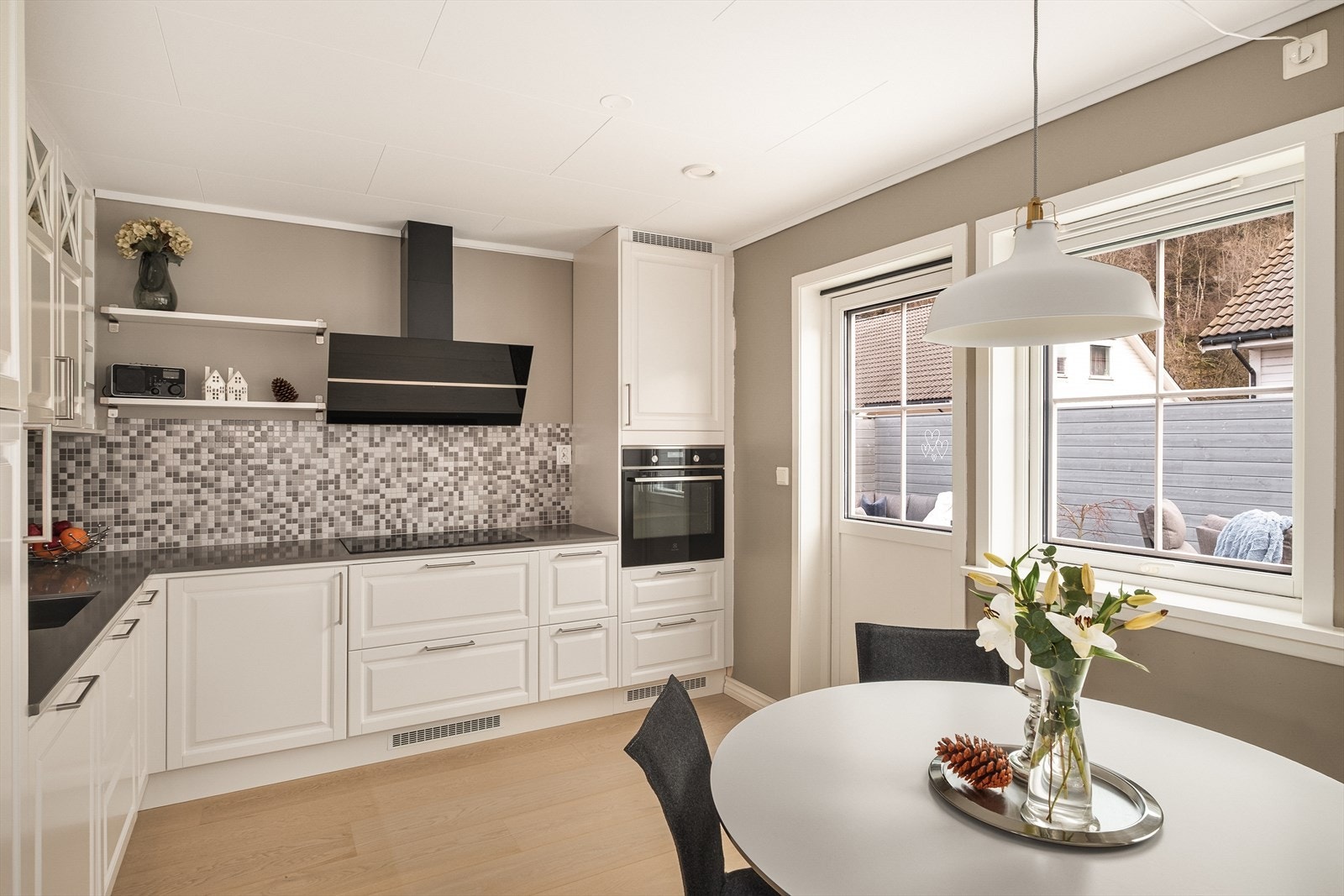 Lekkert kjøkken med intregrert hvitevarer og plass til spisebord. Galleribilde
