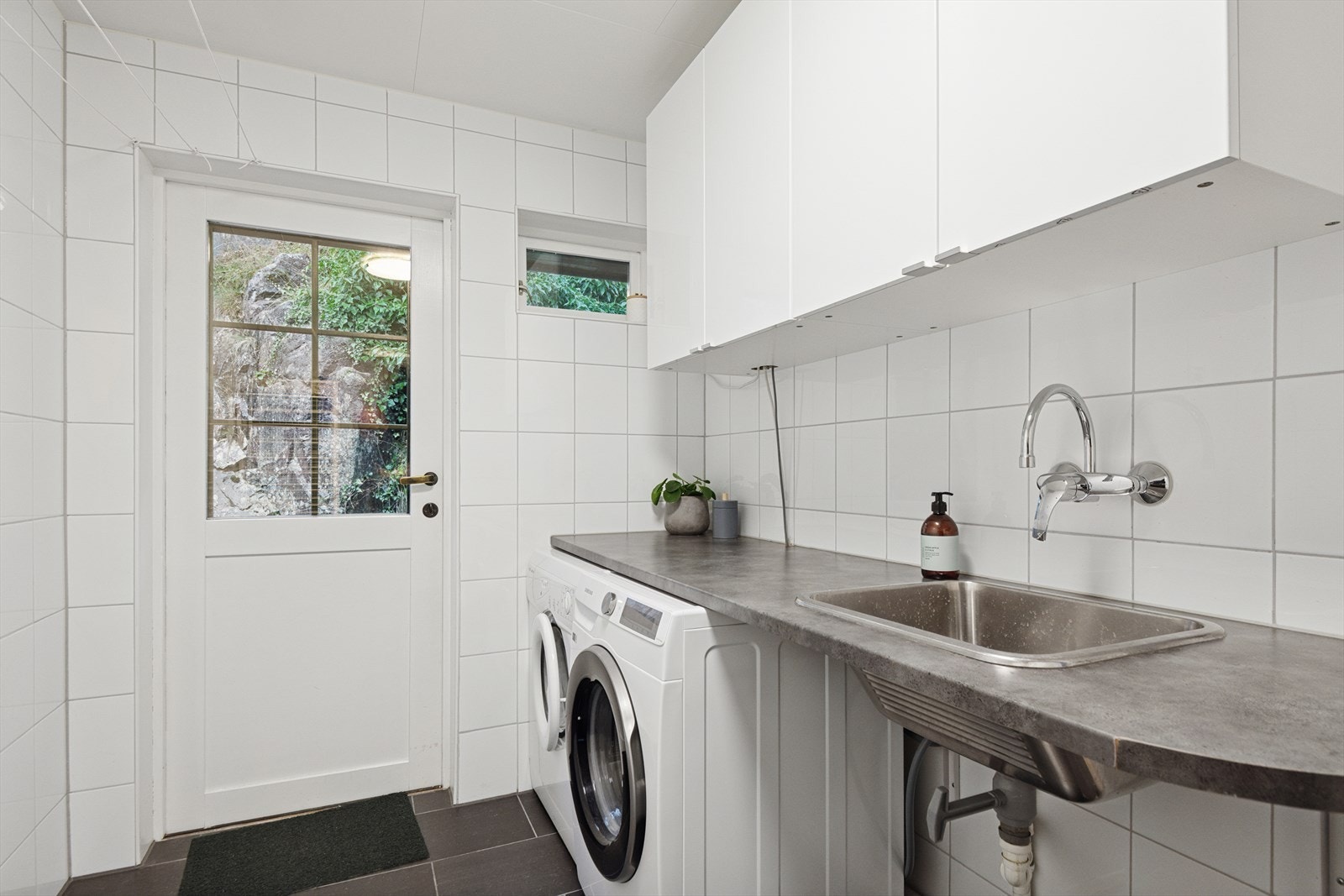 Vaskerom i 1. etasje praktisk innredet med skap, benkeplate og opplegg til vaskemaskin. Galleribilde