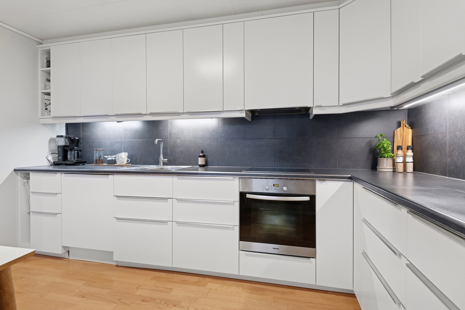 Kjøkkeninnredningen har tidløse slette hvite fronter og laminat benkeplate. Galleribilde