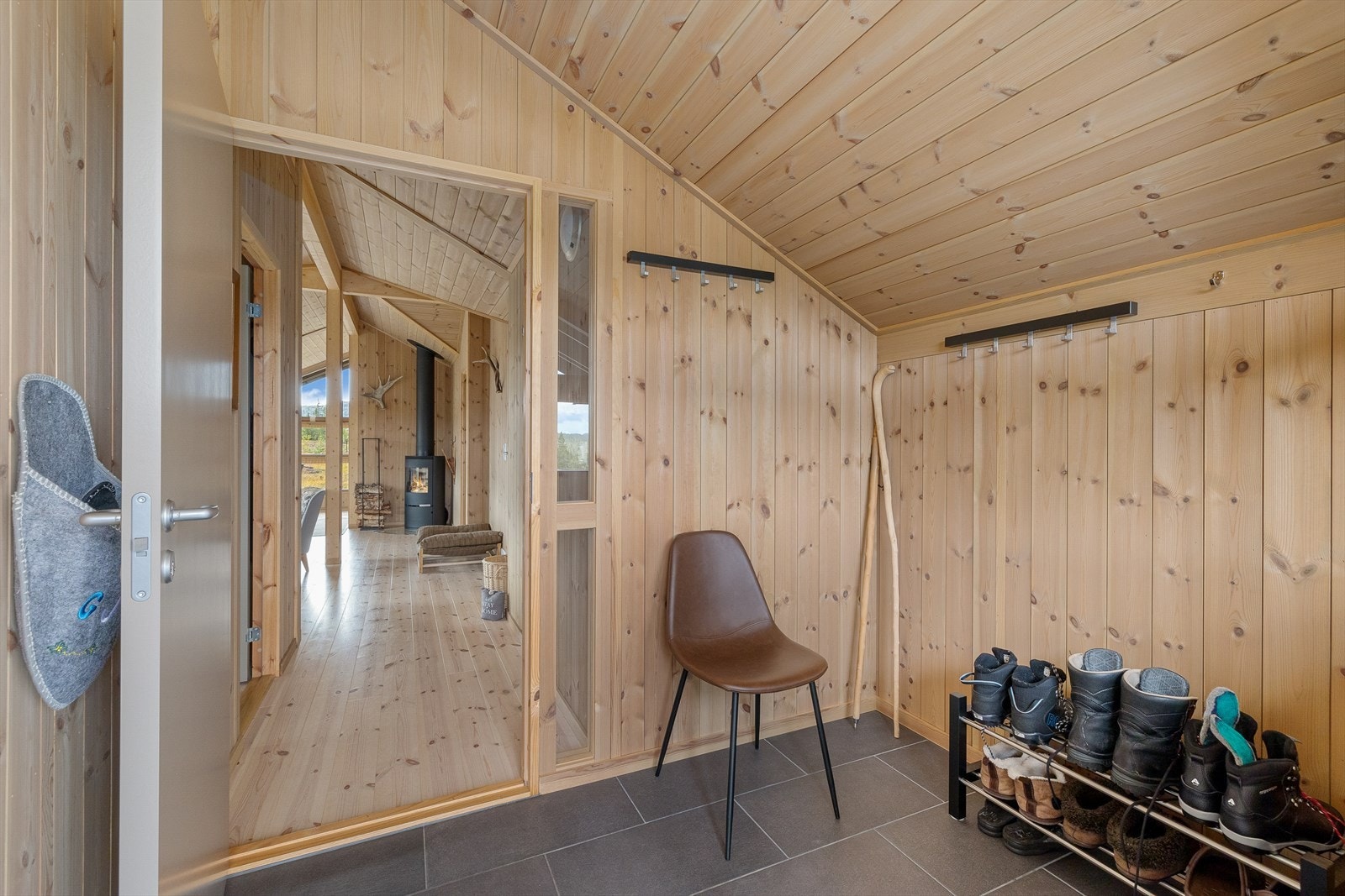 Fra det overbygde inngangspartiet finner du en praktisk entré med flislagt gulv. Galleribilde