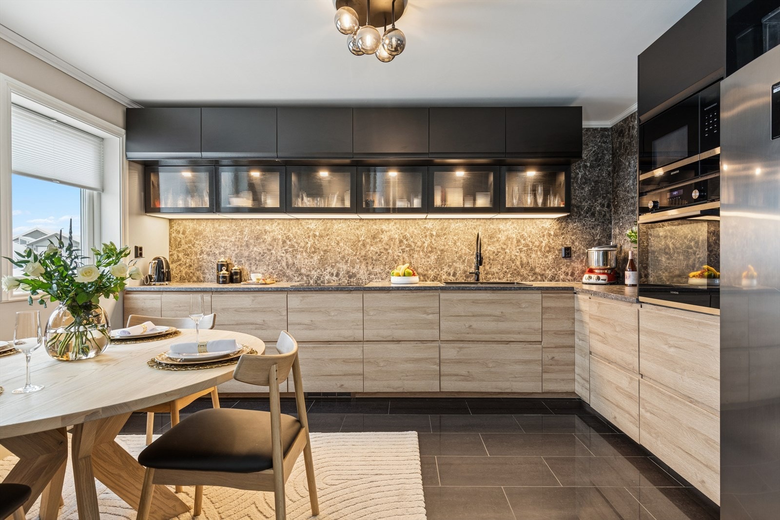 Kjøkkenet har en moderne innredning fra 2023, med glatte fronter og laminert benkeplate med nedfelt kjøkkenkum. Galleribilde