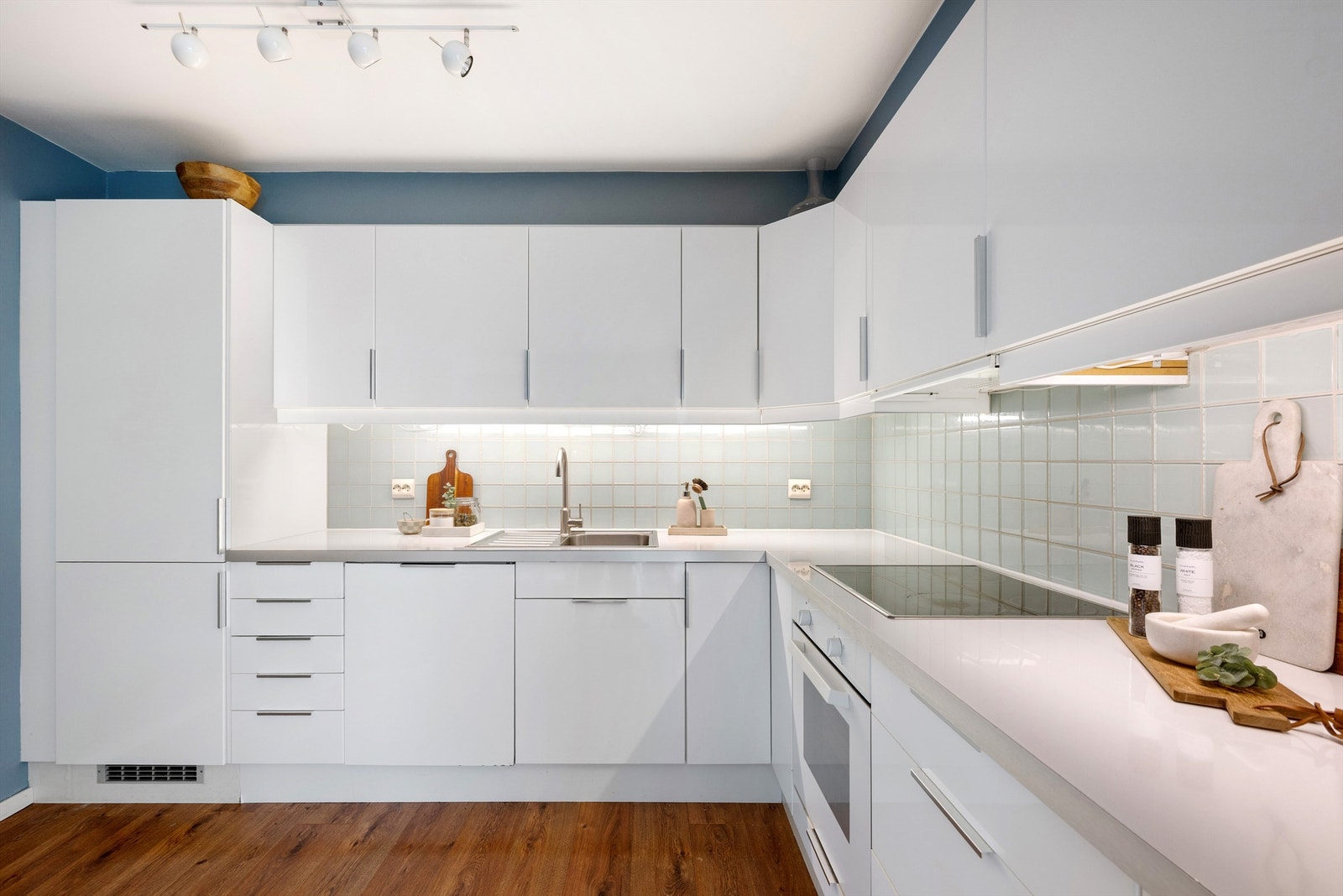 Kjøkken er fra IKEA, og er tidløst i lyse farger, og med laminat benkeplate. Integrerte hvitevarer som kjøleskap med frys, komfyr, oppvaskmaskin og koketopp. Galleribilde