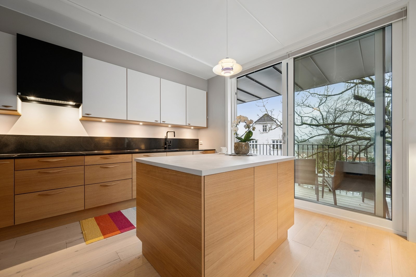 En stor skyvedør i glass åpner opp fra kjøkkenet til balkongen. Galleribilde