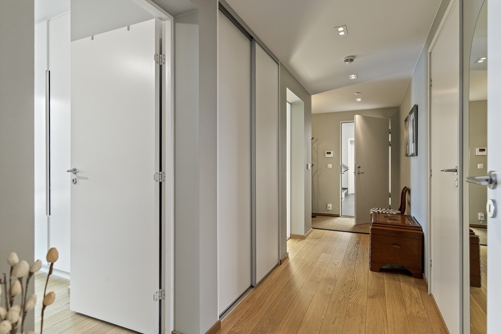 Skyvedørsgarderobe gir effektiv oppbevaring i entréen, mens parkettgulv gir et varmt uttrykk. Galleribilde