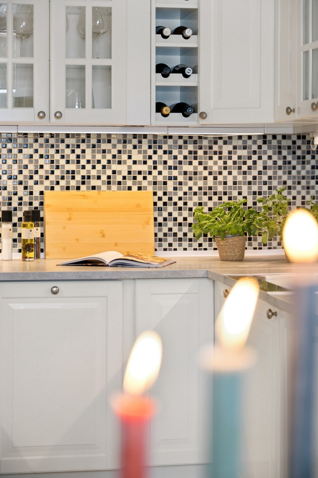 De dekorative mosaikkflisene på veggen over benkeplaten gir kjøkkenet et lekkert blikkfang og tilfører både tekstur og dybde til rommet. Galleribilde