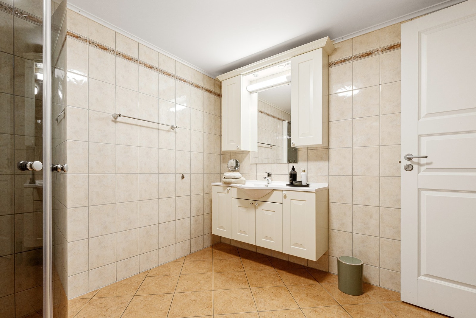 Flislagt, romslig bad med elektriske varmekabler i gulv. Innredning med dusjnisje, vegghengt WC og servantseksjon. Galleribilde