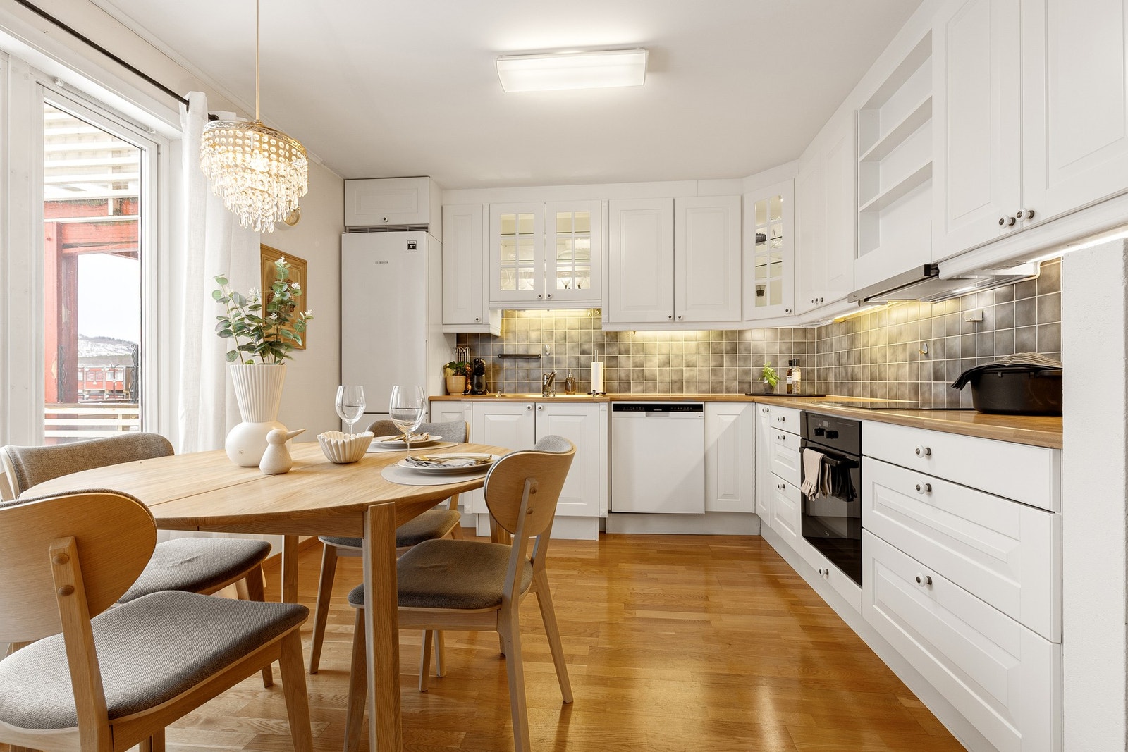 Kjøkkenet har profilerte, hvite fronter med god skap- og benkeplass. Galleribilde