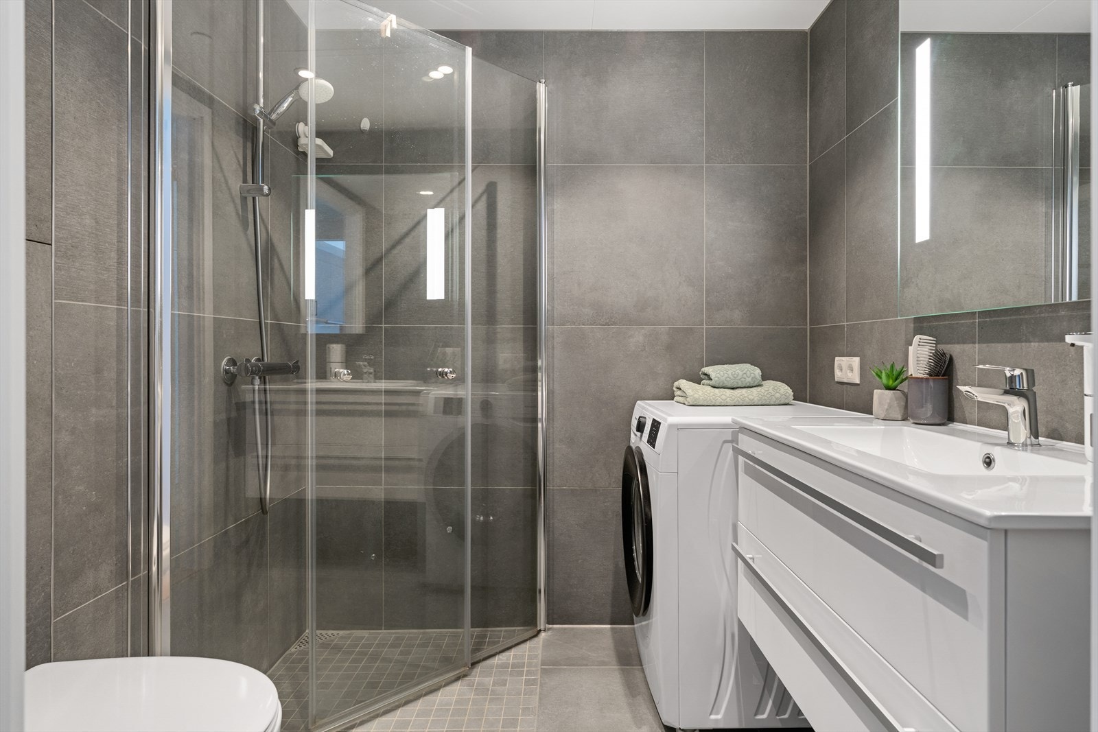 Lekkert bad med 60x60 fliser i stilrent fargevalg. Behagelig varme i gulv og flott belysning med innfelte spotter i tak. Galleribilde