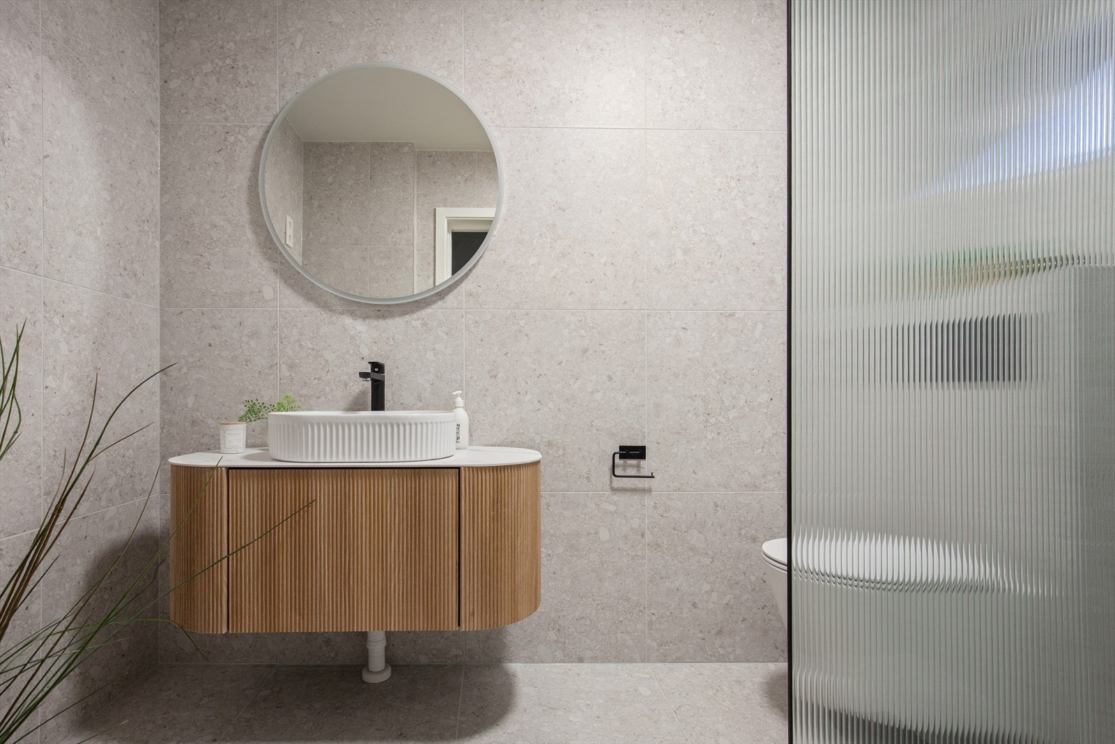 Pent flislagt baderom fra 2025 med behagelig gulvvarme. Rommet er utstyrt med vegghengt toalett, dusj med glassvegg, baderomsinnredning med servant, samt opplegg for vaskemaskin. Galleribilde