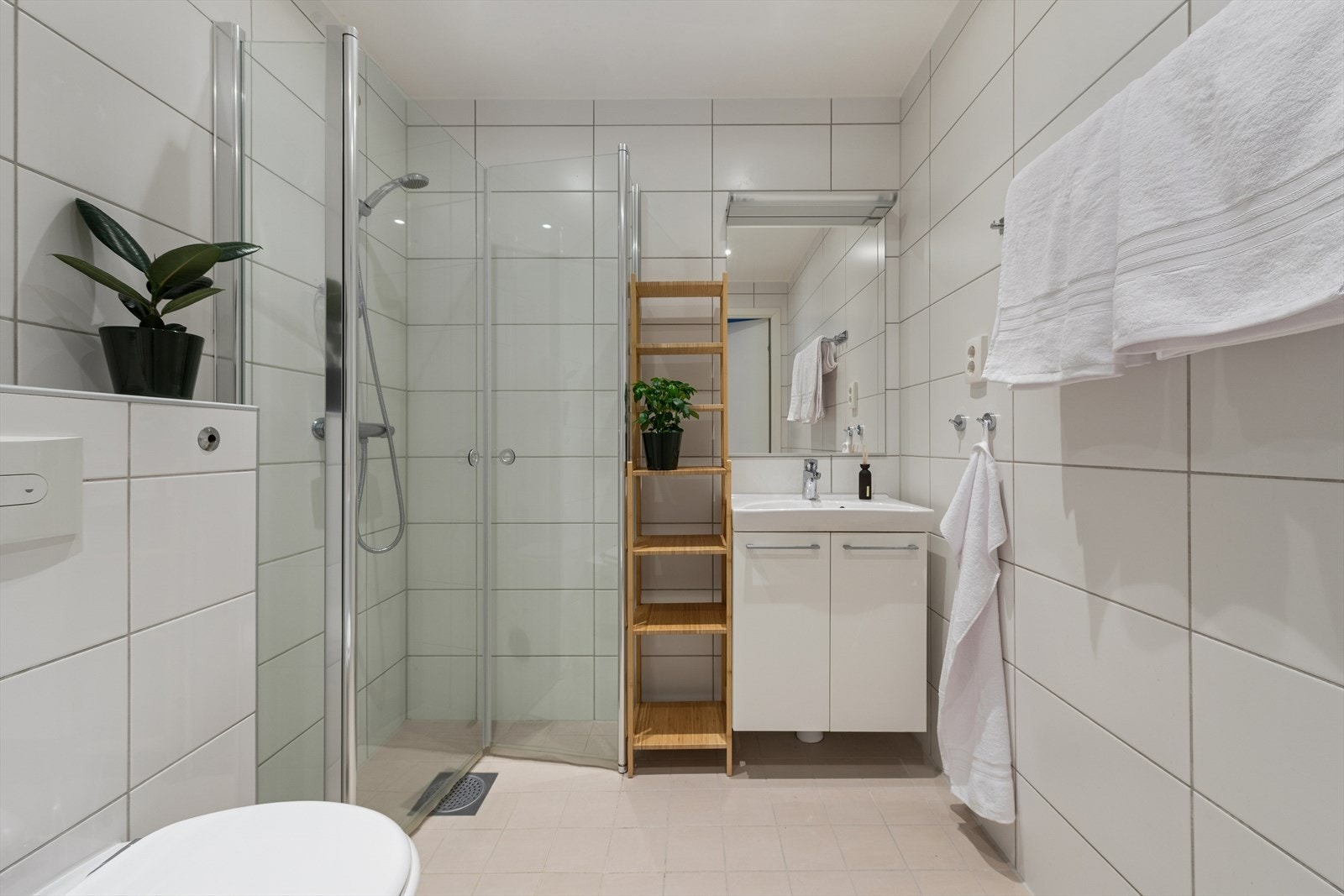 Lyst og pent bad/vaskerom, med løsninger fra byggeåret. Fliser på gulv og vegger. Det er montert downlights i himlingen, og det er lagt elektriske varmekabler i gulvet. Galleribilde