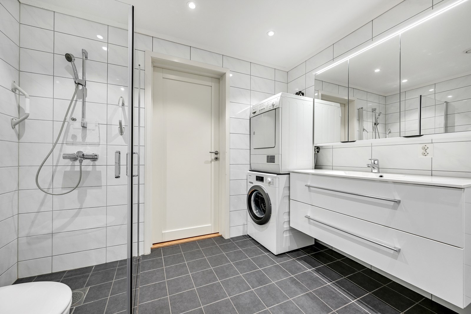 Innredet med stort servant- og speilskap m/belysning, vegghengt toalett og dusjhjørne. Mulighet for badekar. Galleribilde