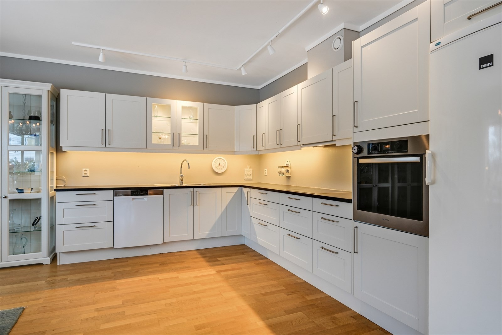 Kjøkkenet er innredet med en klassisk, hvit Sigdal-kjøkkeninnredning med integrerte hvitevarer. Galleribilde