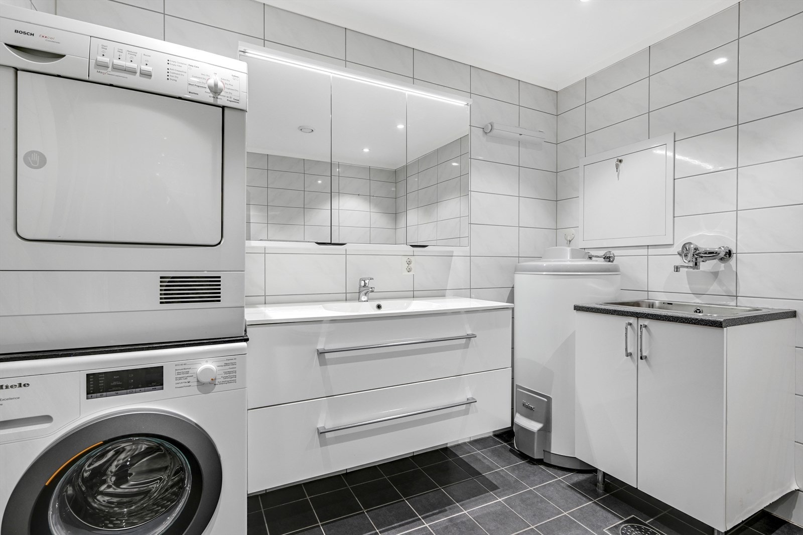 Innerst i rommet finnes en egen vaskeavdeling med skap og nedfelt kum. Galleribilde