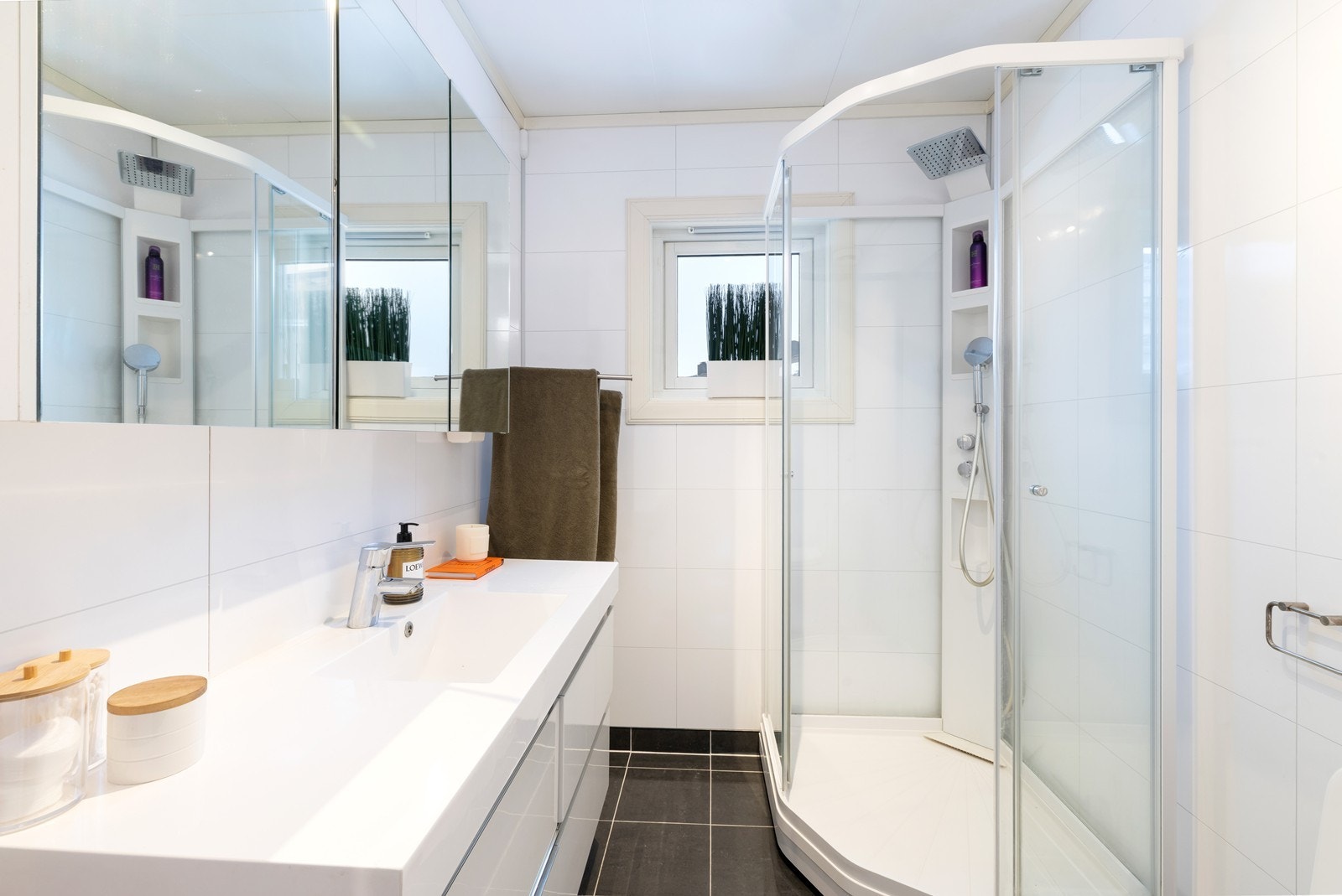 Badet inneholder toalett, servant med over og underskap og dusjkabinett. Galleribilde