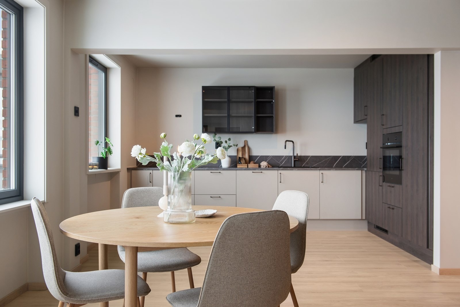 Kjøkkenet har en tidløs og moderne innredning fra 2026, med glatte fronter og laminert benkeplate med nedfelt kjøkkenkum. Galleribilde