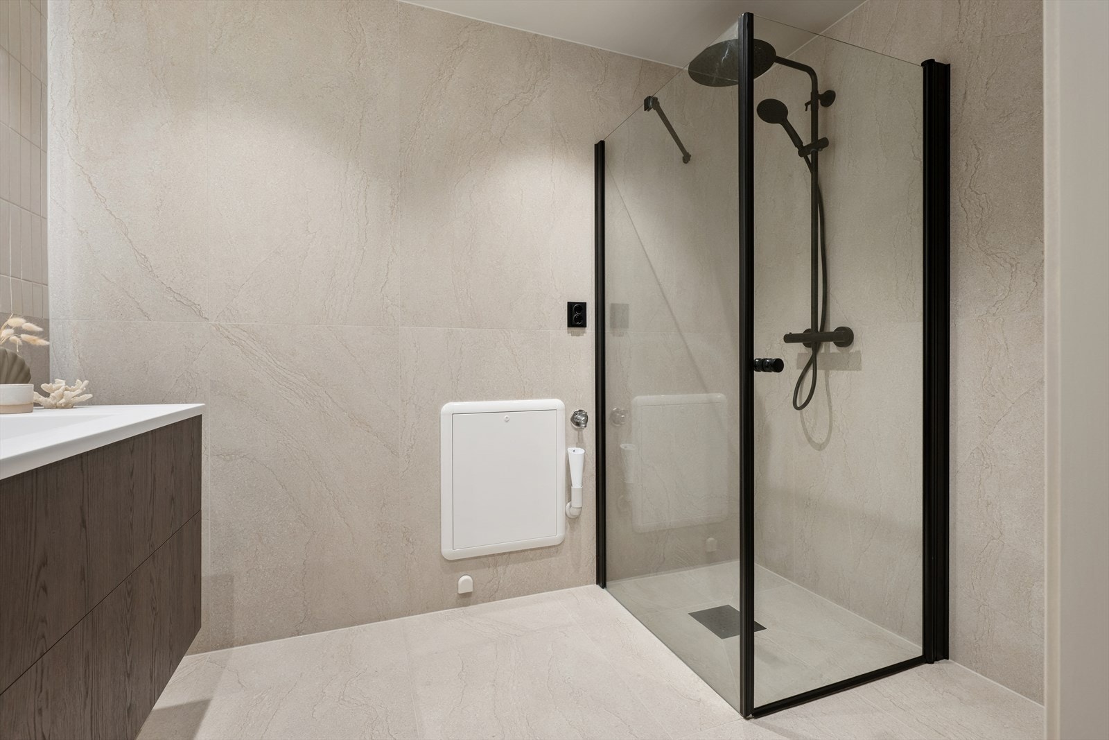 Dusjhjørne med innfellbare glassdører, utstyrt med både hånddusj og regndusj. Galleribilde