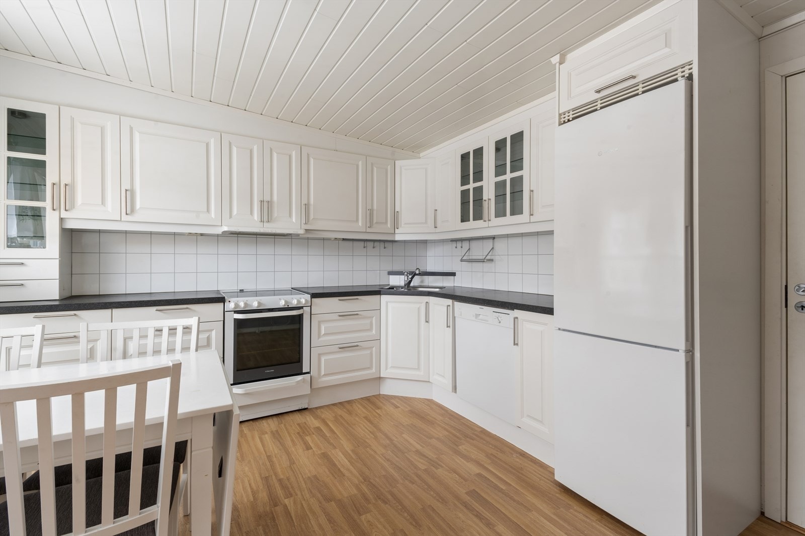 Funksjonell innredning med laminerte fronter, benkeplate og frittstående hvitevarer. Galleribilde