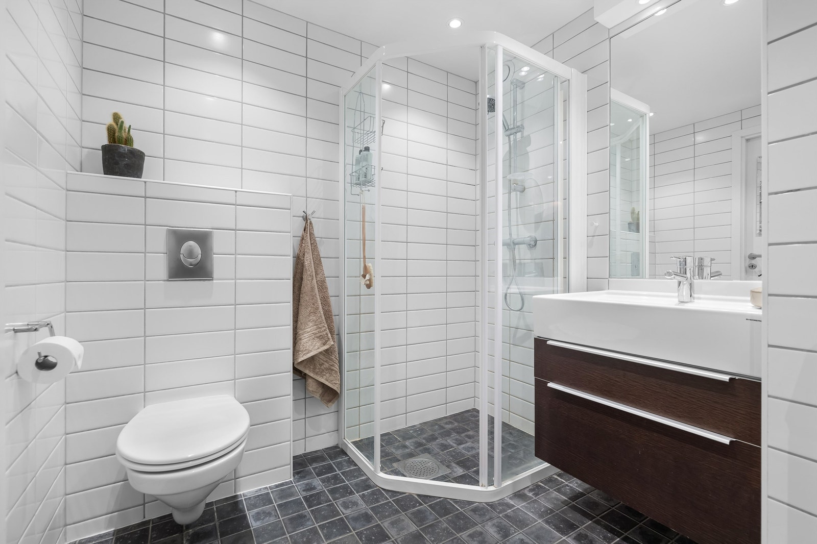 Badet har vegghengt toalett dusjhjørne med skyvedør Galleribilde