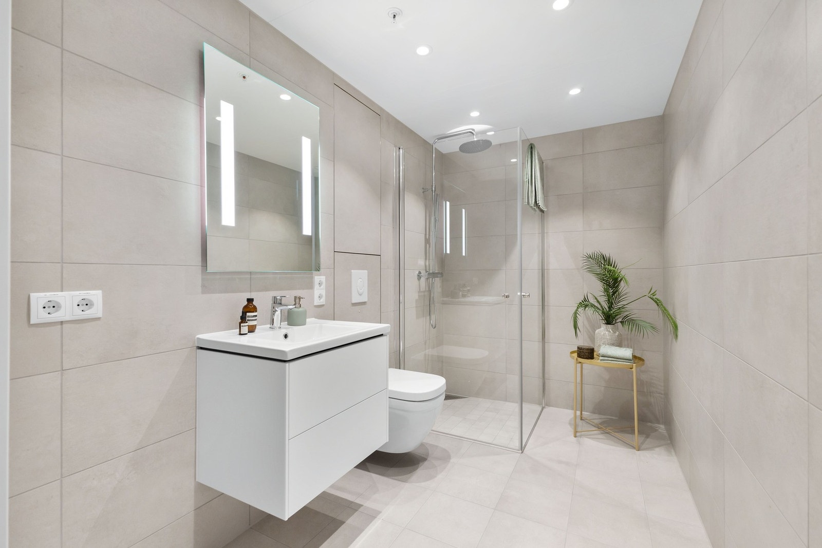 Et stilrent bad med opplegg til vaskemaskin og tørketrommel Galleribilde