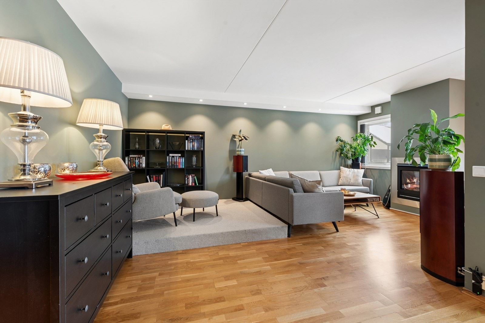 En del av stuen er bygget opp med et løst platå som enkelt kan fjernes dersom ønskelig. Platået skaper en artig brytning i rommet og bidrar til naturlige soner, noe som gir stuen et mer spennende og funksjonelt preg Galleribilde